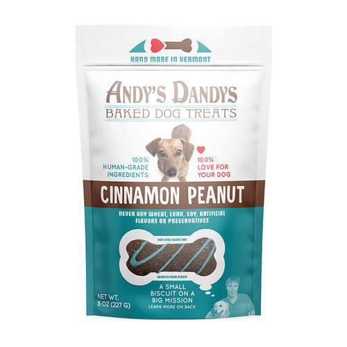 Front of white and blue pouch of tasty Andy's Dandys Cinnamon Peanut flavor mini bone shaped baked dog biscuits drizzled with blue yogurt icing