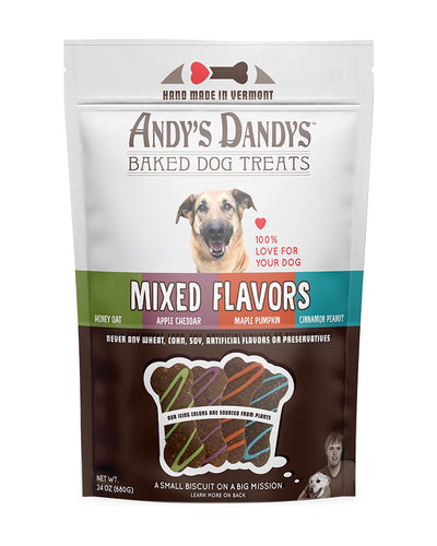 Front of white and brown pouch of tasty Andy’s Dandys Mixed Flavors mini bone and heart shaped baked dog biscuits drizzled with orange green purple and blue yogurt icing