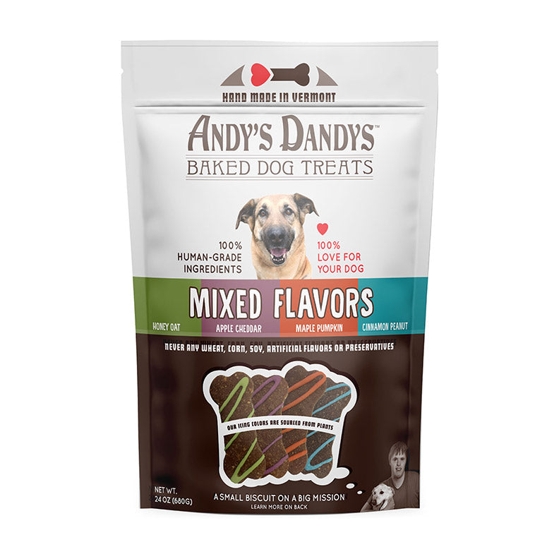 Front of white and brown pouch of tasty Andy’s Dandys Mixed Flavors mini bone and heart shaped baked dog biscuits drizzled with orange green purple and blue yogurt icing